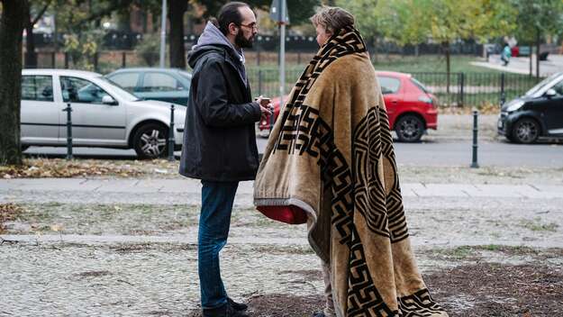 Der Berliner Pfarrer Kaspar Plenert spricht mit einer Besucherin des Leopoldplatzes 