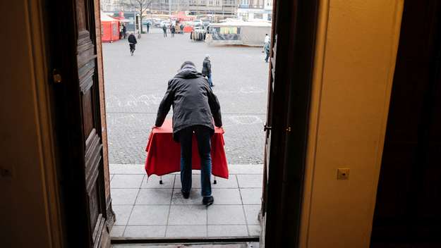 Pfarrer Kaspar Plenert stellt den roten Tisch vor seine Kirchentür