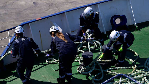 Crew-Mitglieder ziehen Taue der Sea-Watch ein.