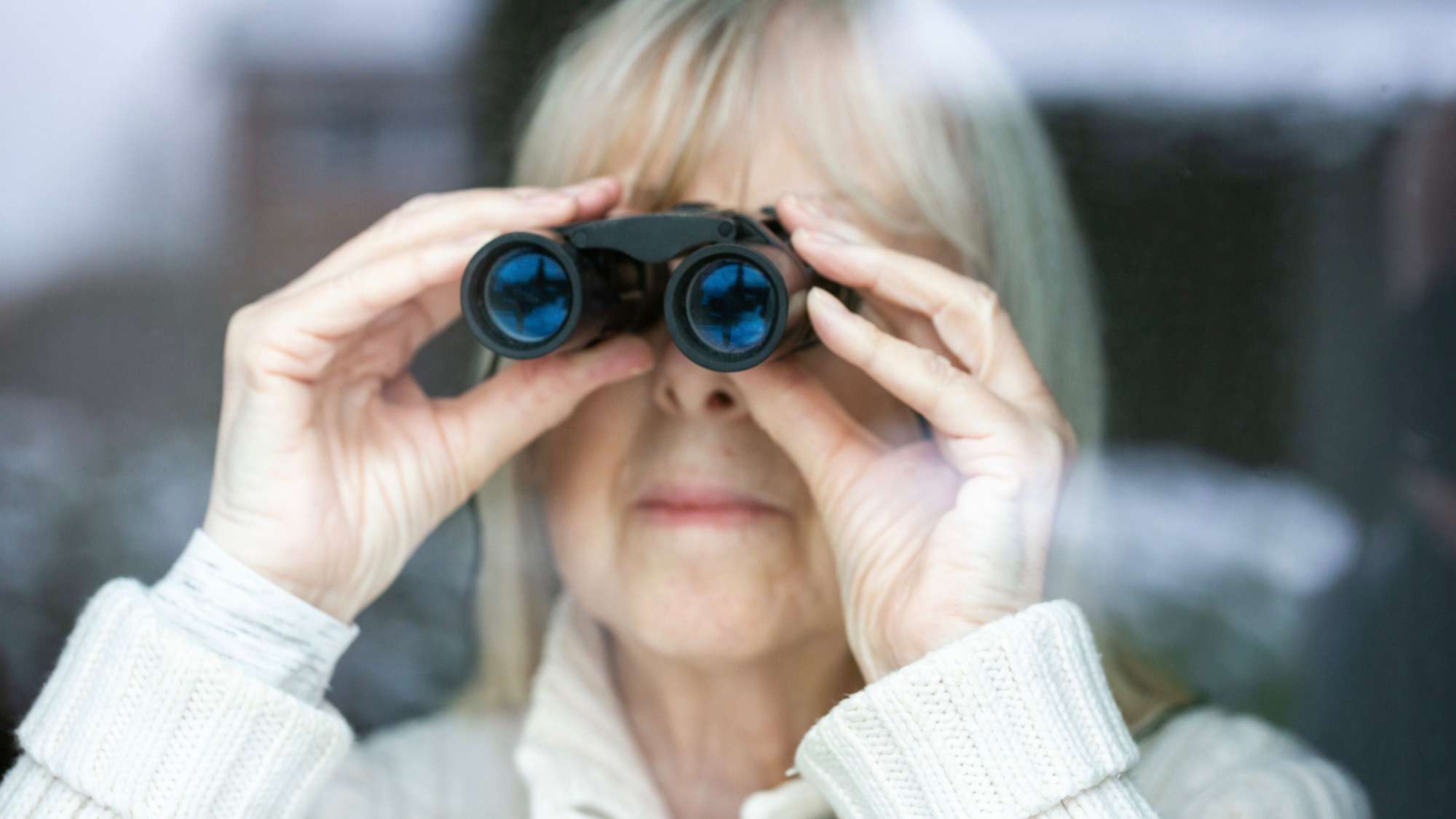 Symbolbild: Eine ältere Frau schaut durch ein Fernglas