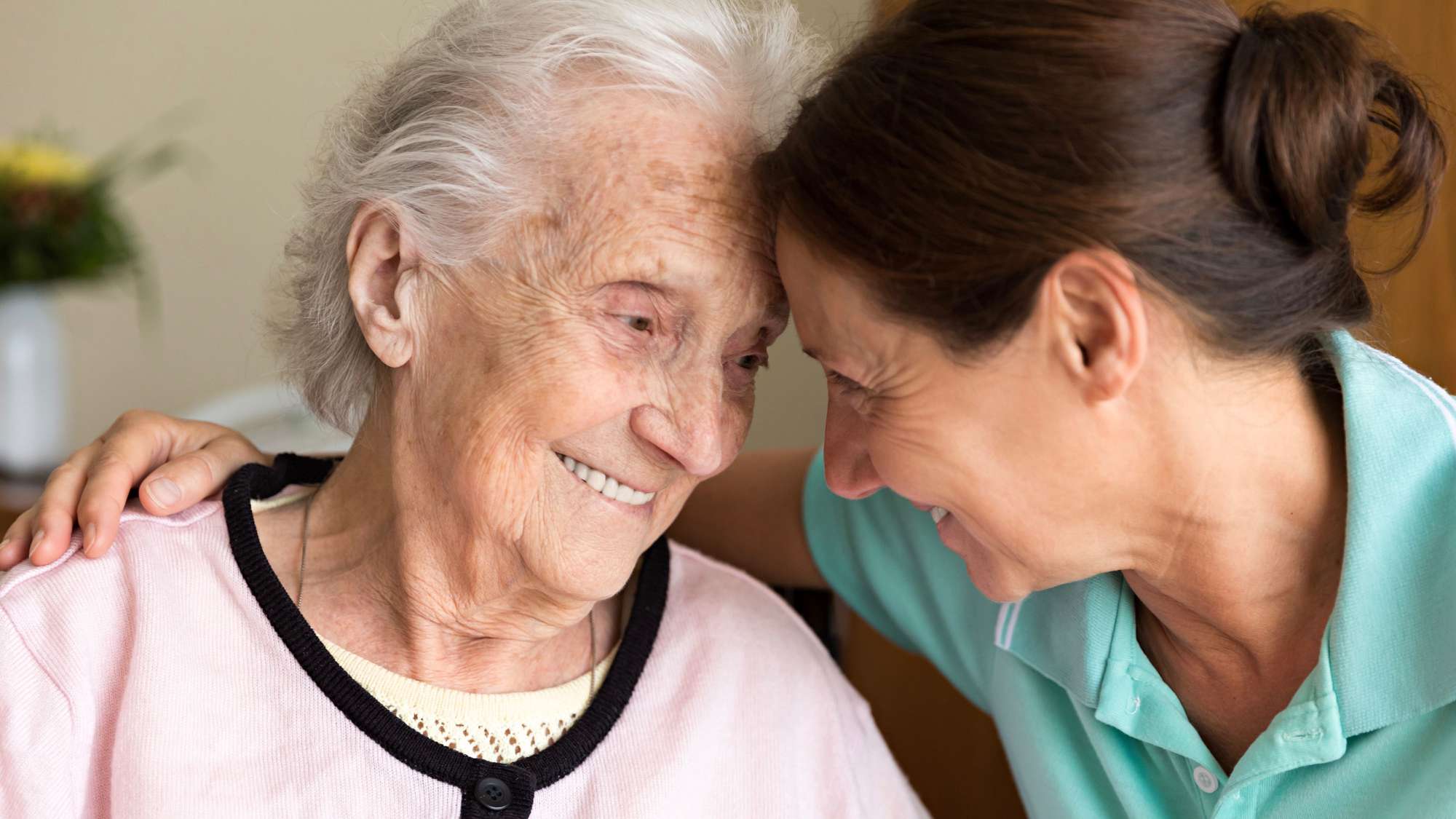 Eine Pflegerin nimmt eine alte Frau in den Arm