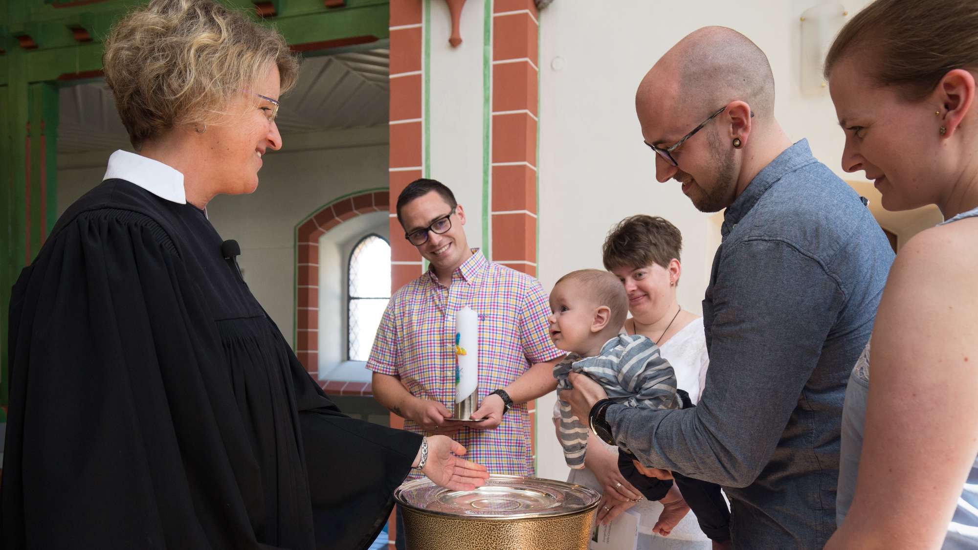 Eine Pfarrerin tauft ein Kleinkind