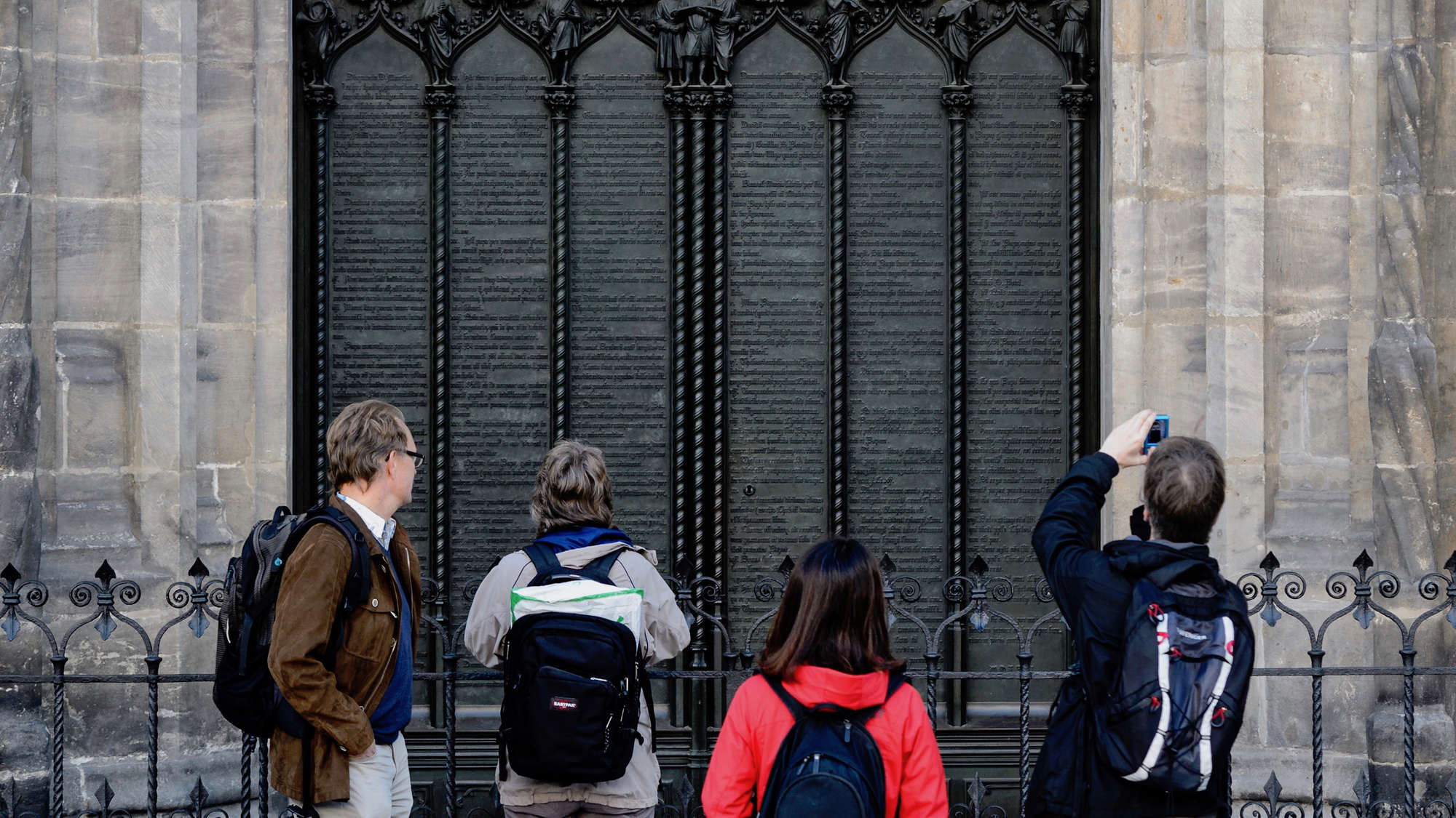 Besucher vor der Thesentür der restaurierten Schlosskirche in Wittenberg