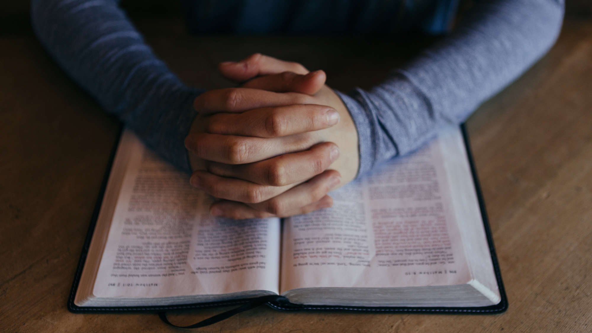 Gefaltete Hände und eine Bibel