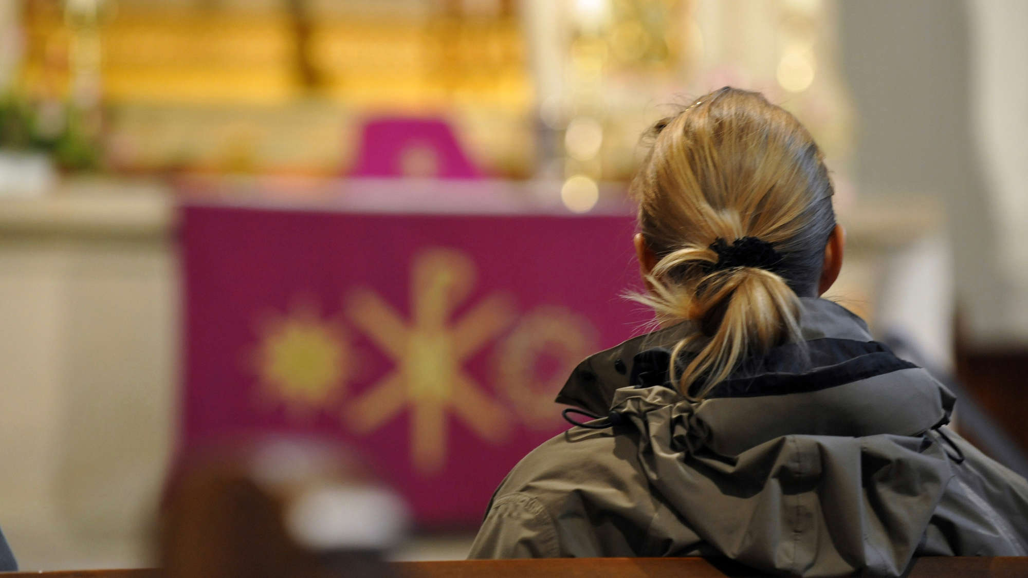 Eine Frau sitzt in einer Kirche