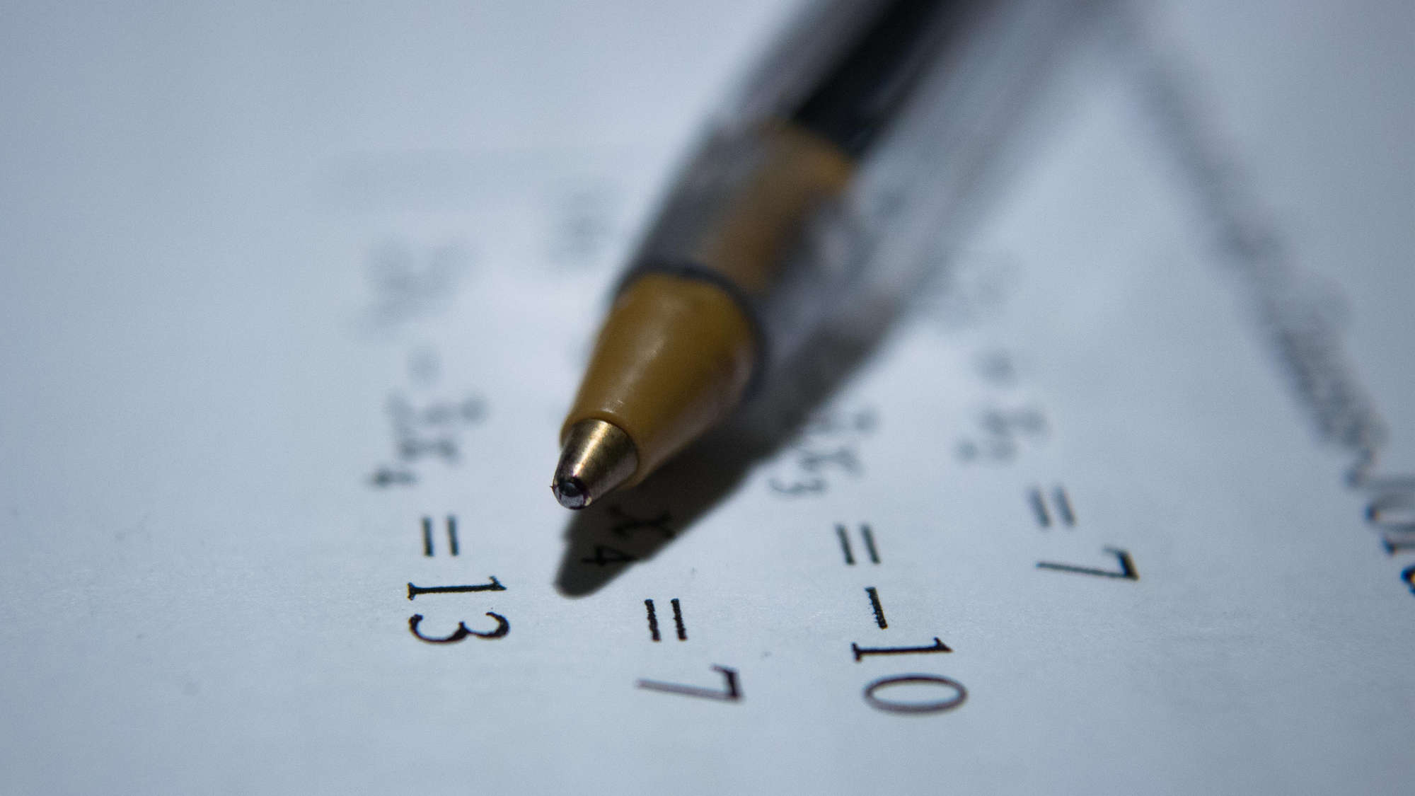 Symbolbild Zahlen und Fakten: Kugelschreiber liegt auf Papier mit abgedruckten Zahlen und Rechnungen