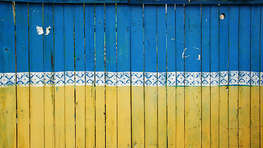 Holzzaun in den Farben der ukrainischen Flagge